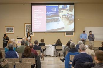 Students standing and speaking in front of an audience presenting their project work