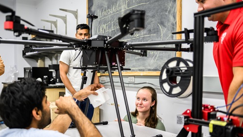 WPI students in a research lab work on a drone.