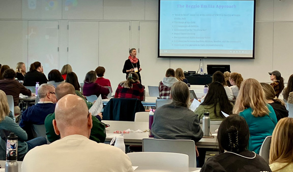 Featured speaker speaking during keynote session with large audience listening