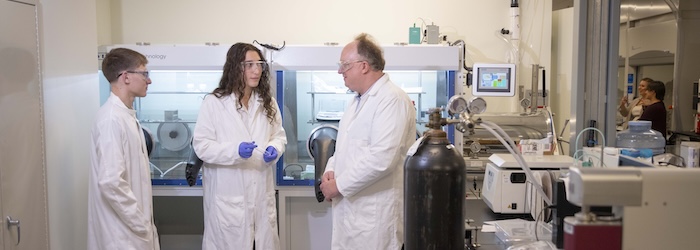 Worcester Polytechnic Institute students and a professor stand together inside a materials science lab