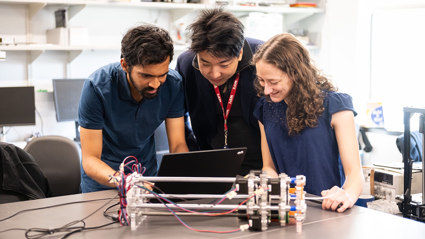 Students at Worcester Polytechnic Institute graduate school examine a device in a lab