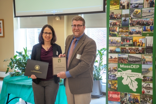 Professor receives awards certificates from environmental protection official