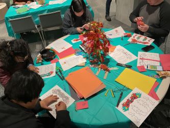 students crafting dragon puppets