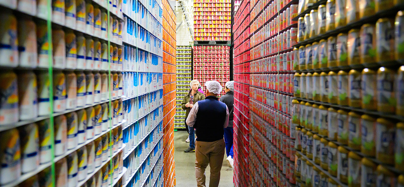 People walk through a warehouse of products from Polar in Worcester during a WPI site visit