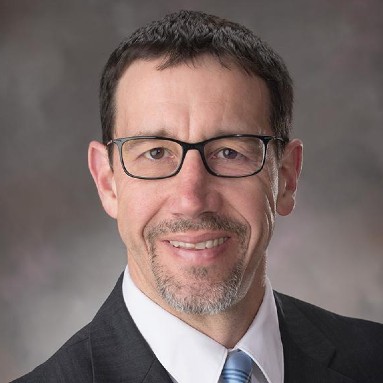 Headshot of Daniel Linzell in a suitcoat and tie