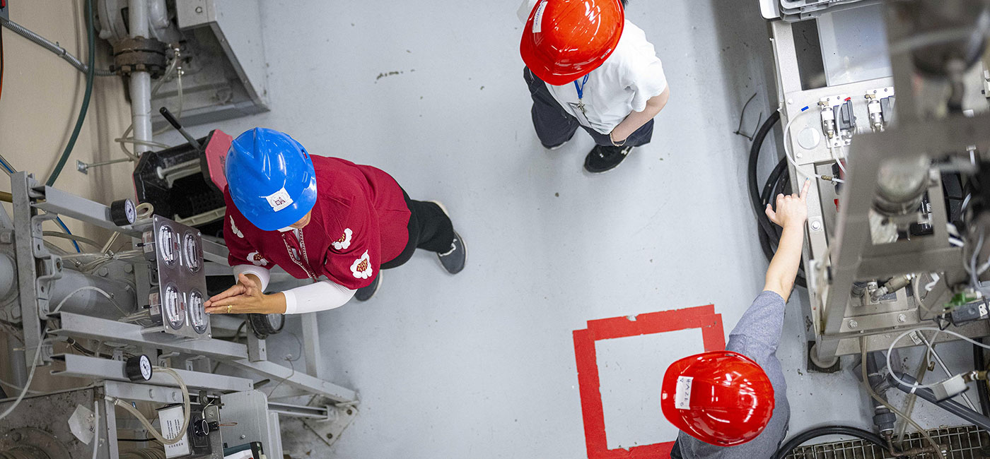 Looking down on people wearing red hard hats in a factory