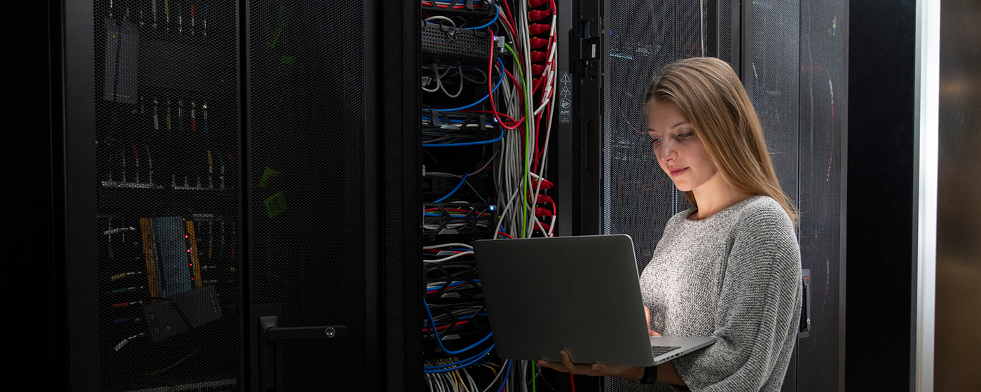WPI student in server room with laptop