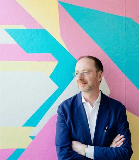 Man in front of colorful abstract background