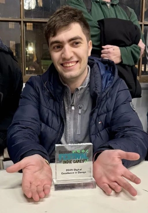 Bashar Alqassar smiling posing with award trophy