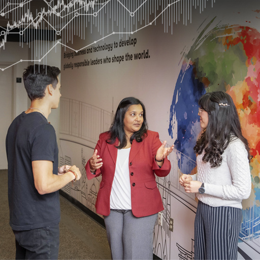 WPI Business School Professor Purvi Shah talks with two students in front of a wall mural featuring an abstract, colorful Earth.