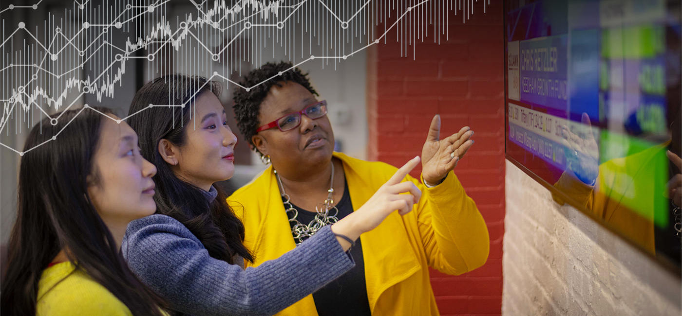 Professor and students looking at stock market news on a television.