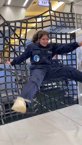 Student in flight suit levitating in mid-air inside a plane during zero-gravity moment