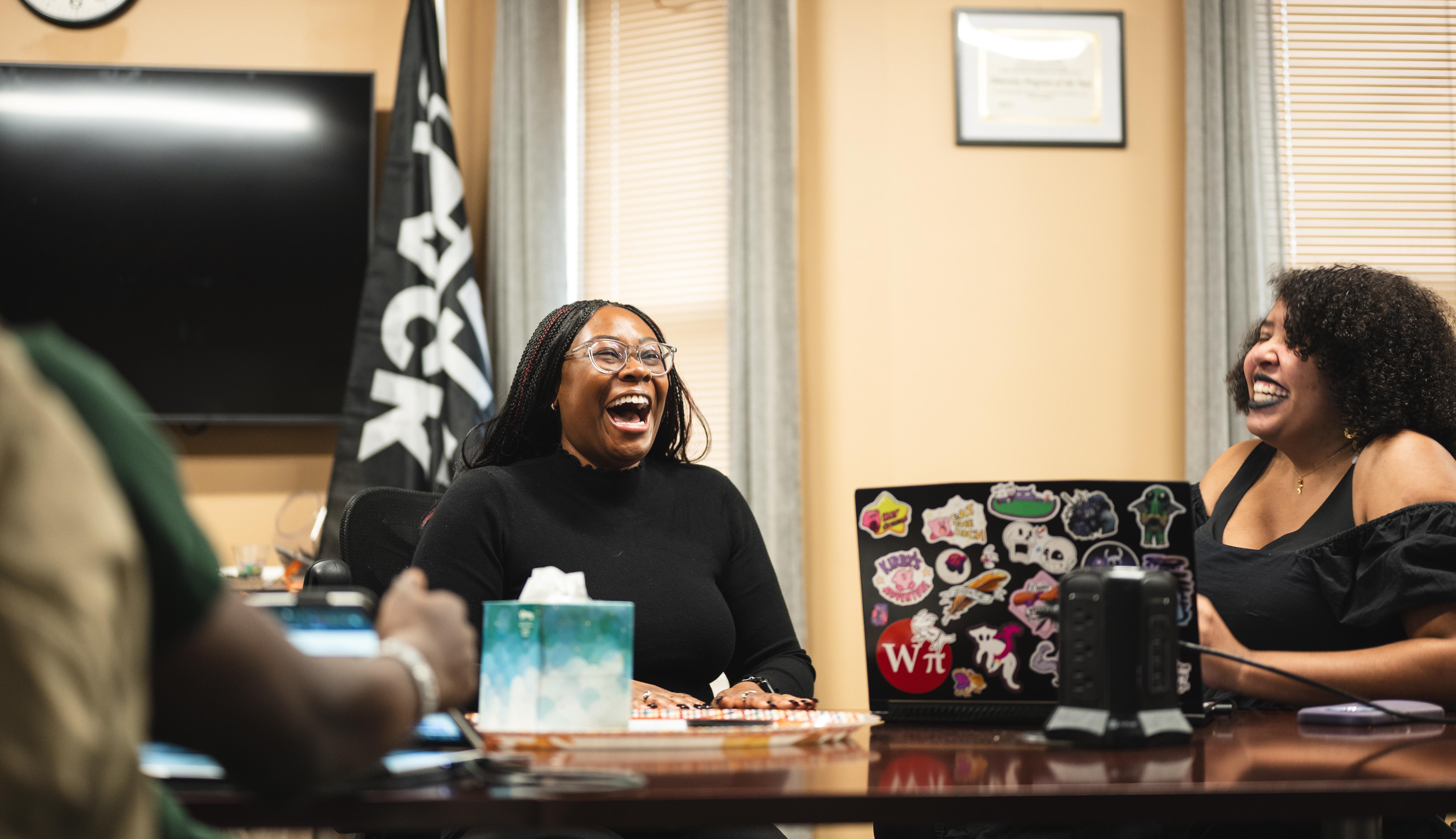 two women sitting at a table laughing
