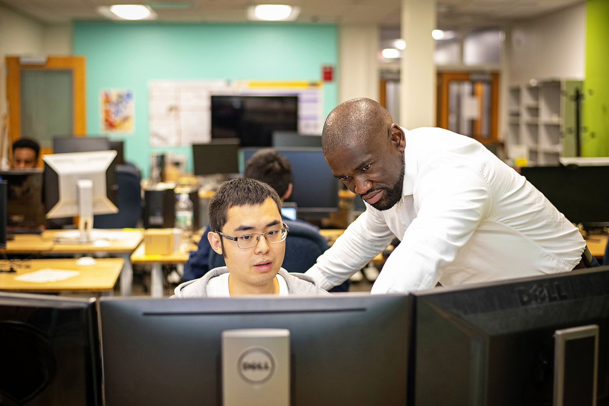 Two individuals looking at a computer.