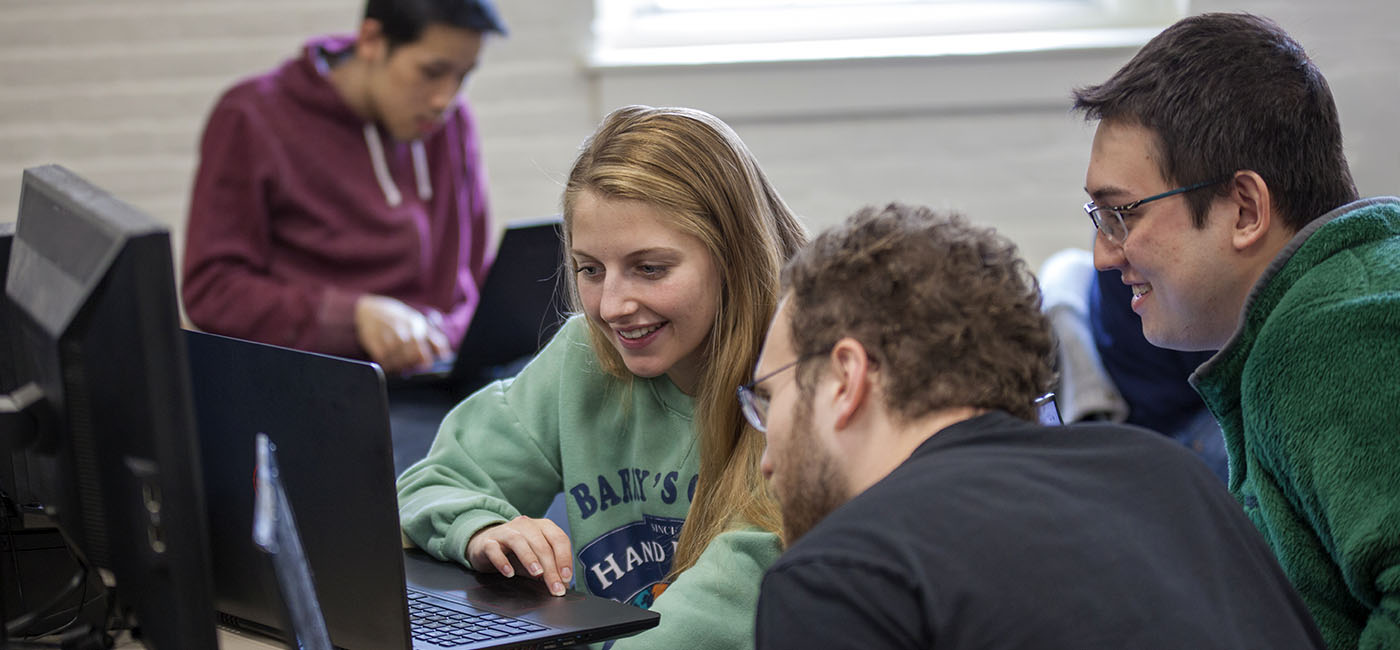 WPI students huddled around laptop in lab