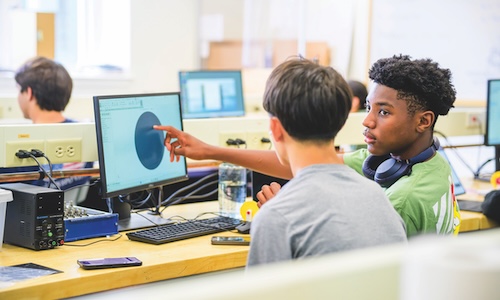 Two high school students in WPI's Frontiers summer STEM program, collaborating together in front of a computer.