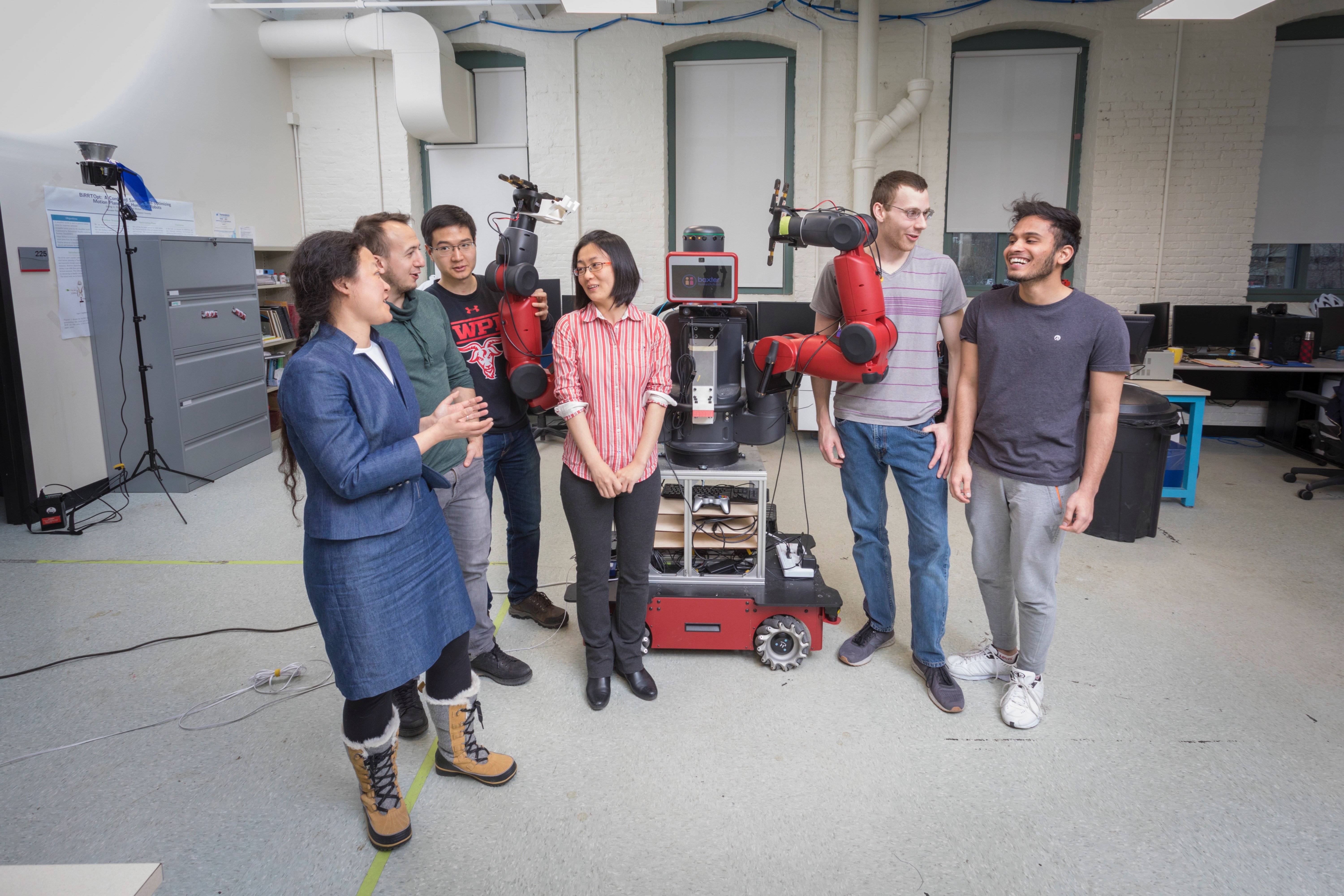 group of people standing around robot