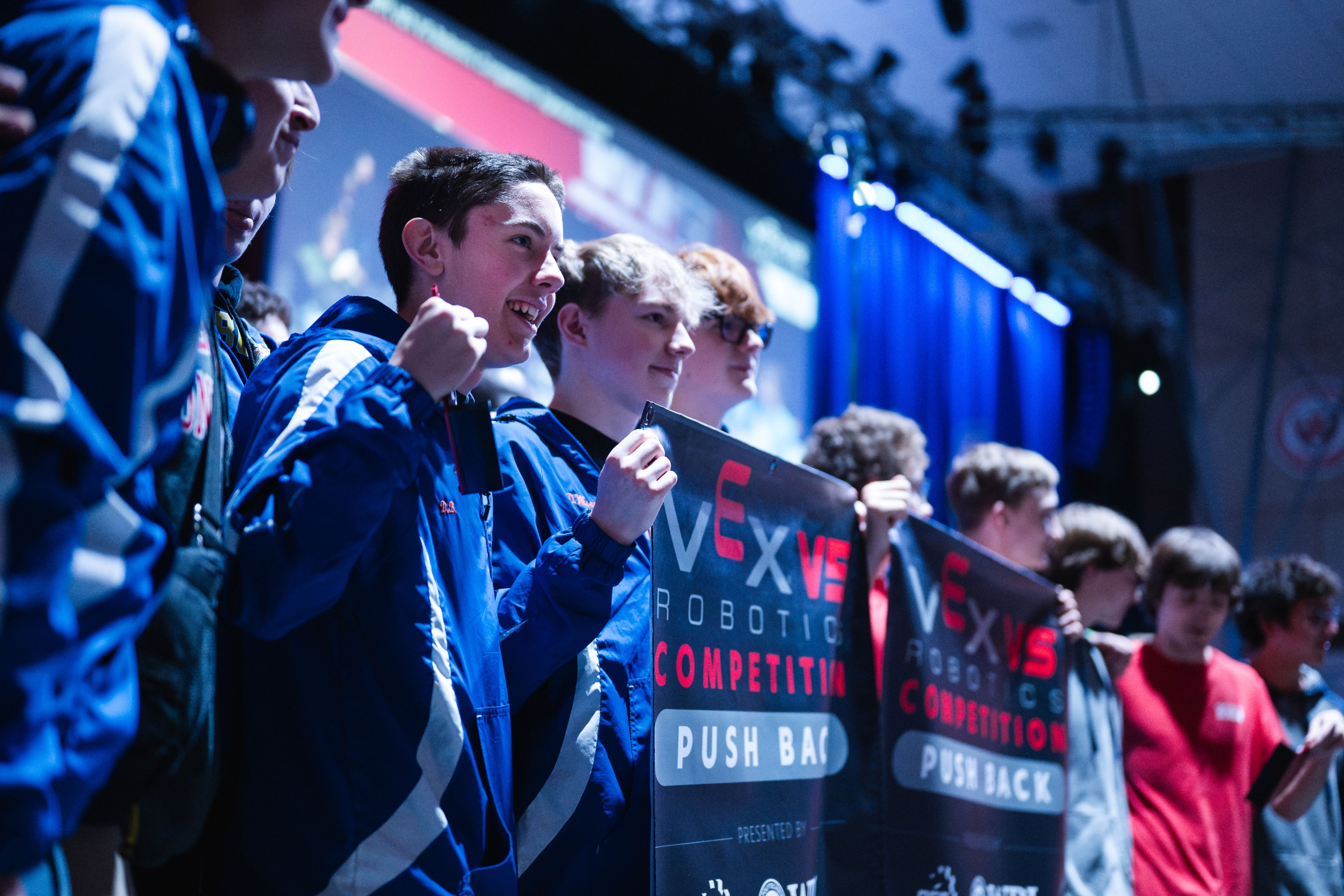 A team holding up a banner that says VEX