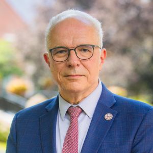 A man in a suit on the campus of Worcester Polytechnic Institute.