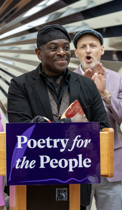 Poet Regie Gibson holding a Webster's dictionary at his May 2025 swearing-in