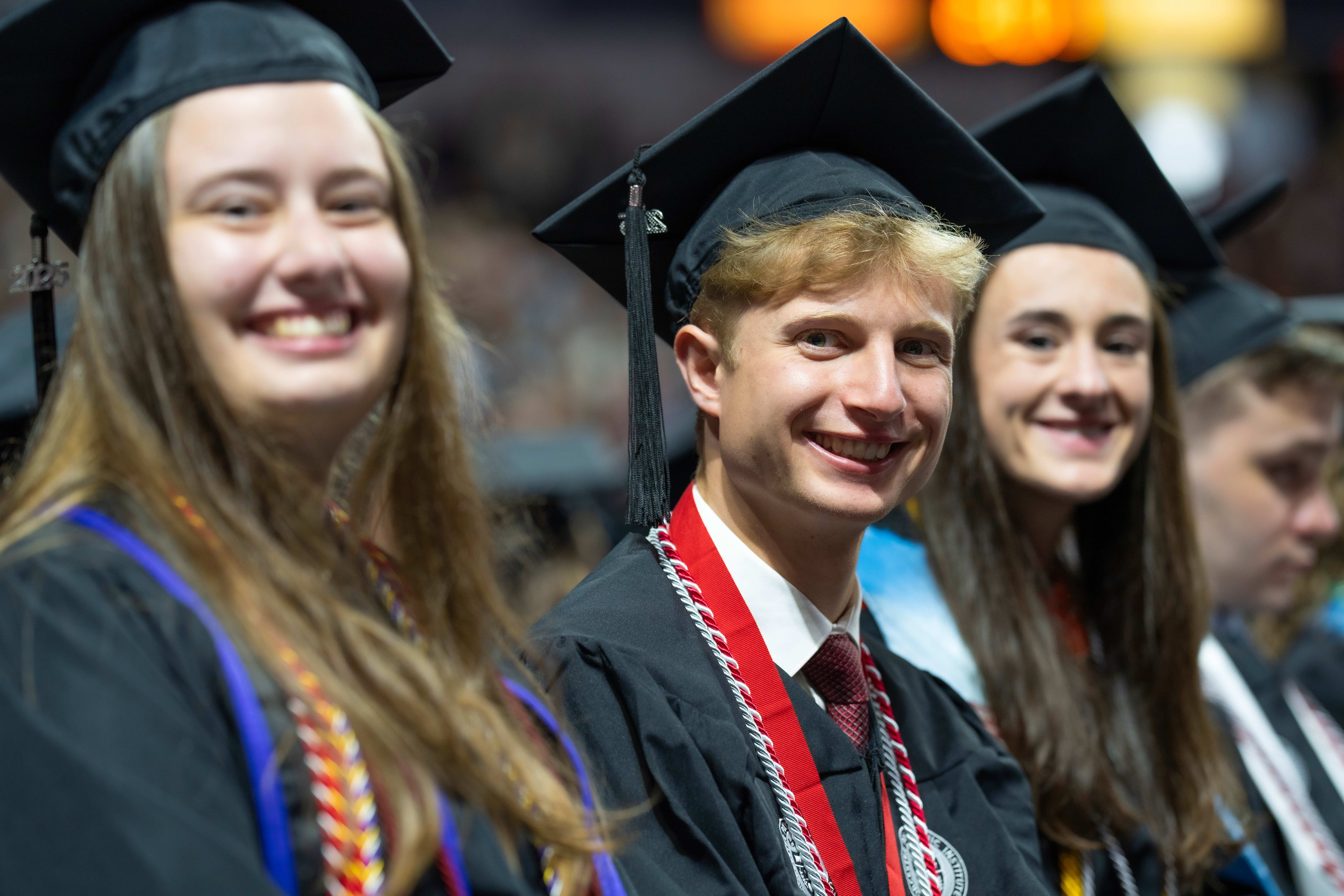 undergraduate students sitting at WPI graduation, smiling