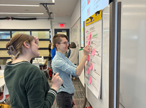Attendee at the STEM Education Showcase writing on chart paper.
