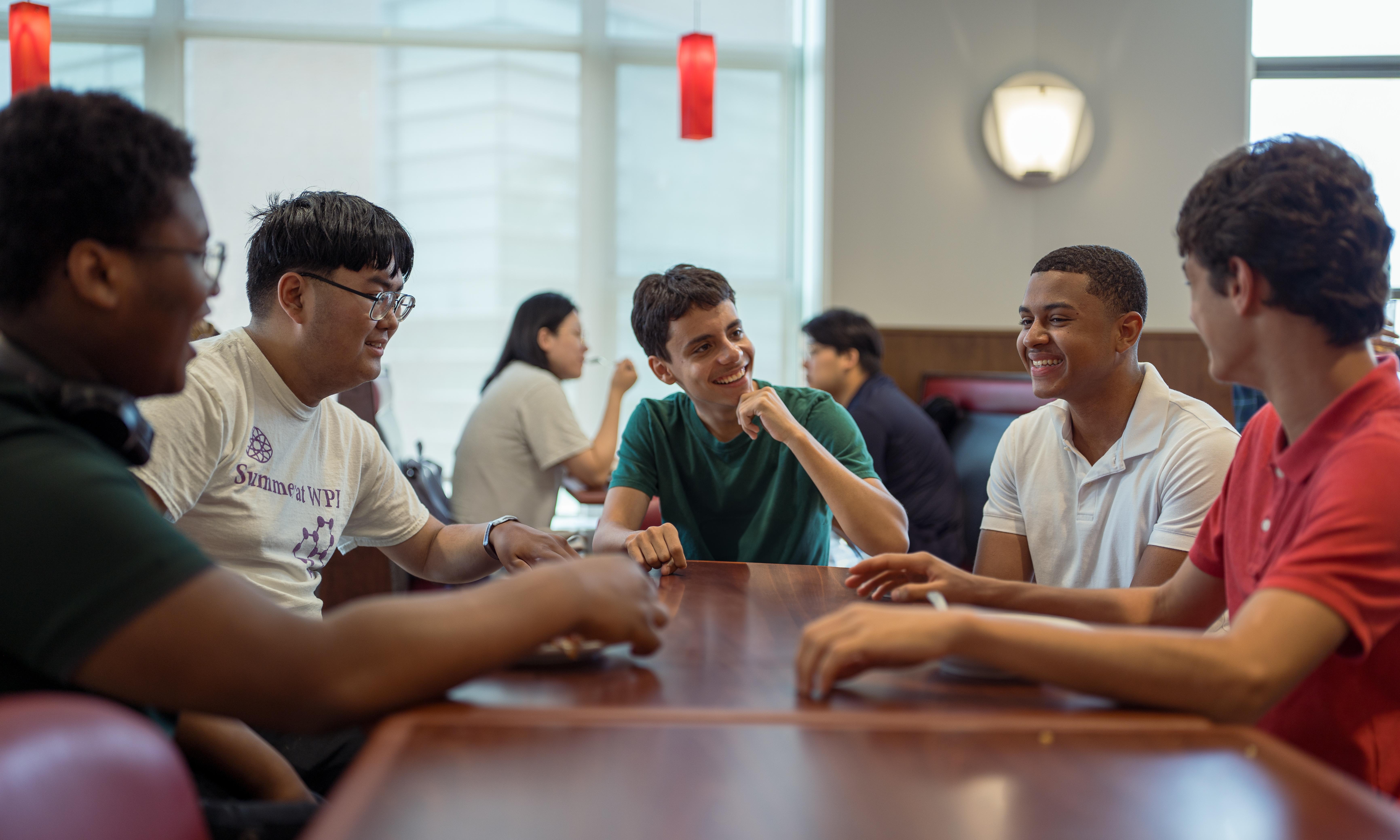 WPI students laughing over lunch in the dining hall