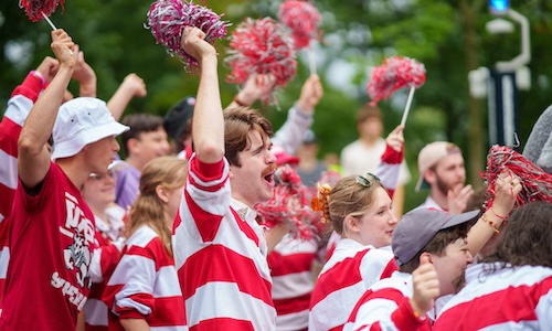 WPI students wearing school colors wave pom-poms and cheer on new students