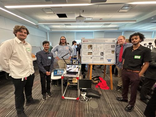 students standing next two chess playing robot