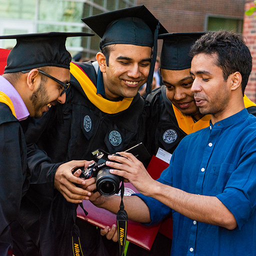 WPI Graduates huddled around camera