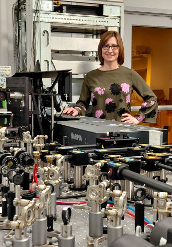 Lyubov Titova stands behind a desk in her lab