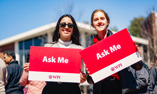 Two students welcoming visitors to WPI campus