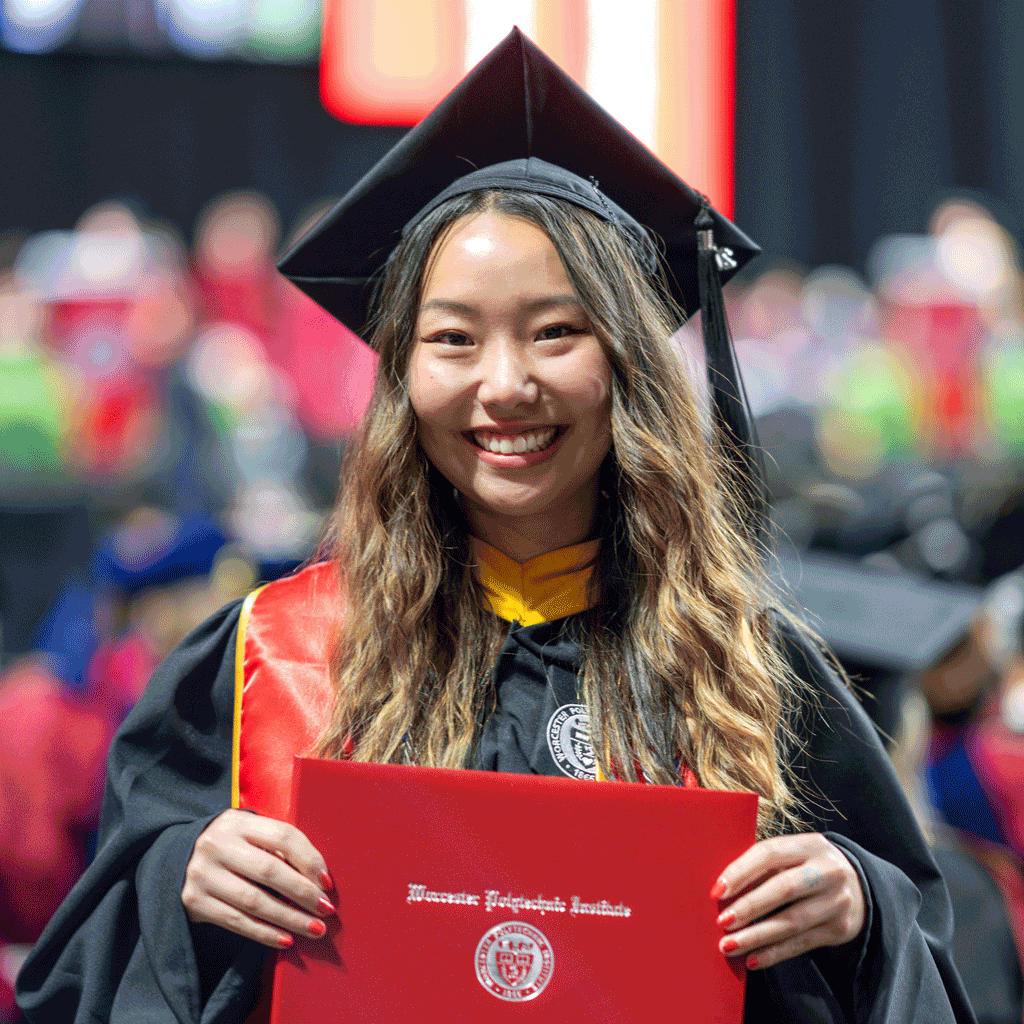 WPI Graduate posing with diploma