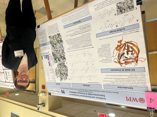 female student standing next to poster