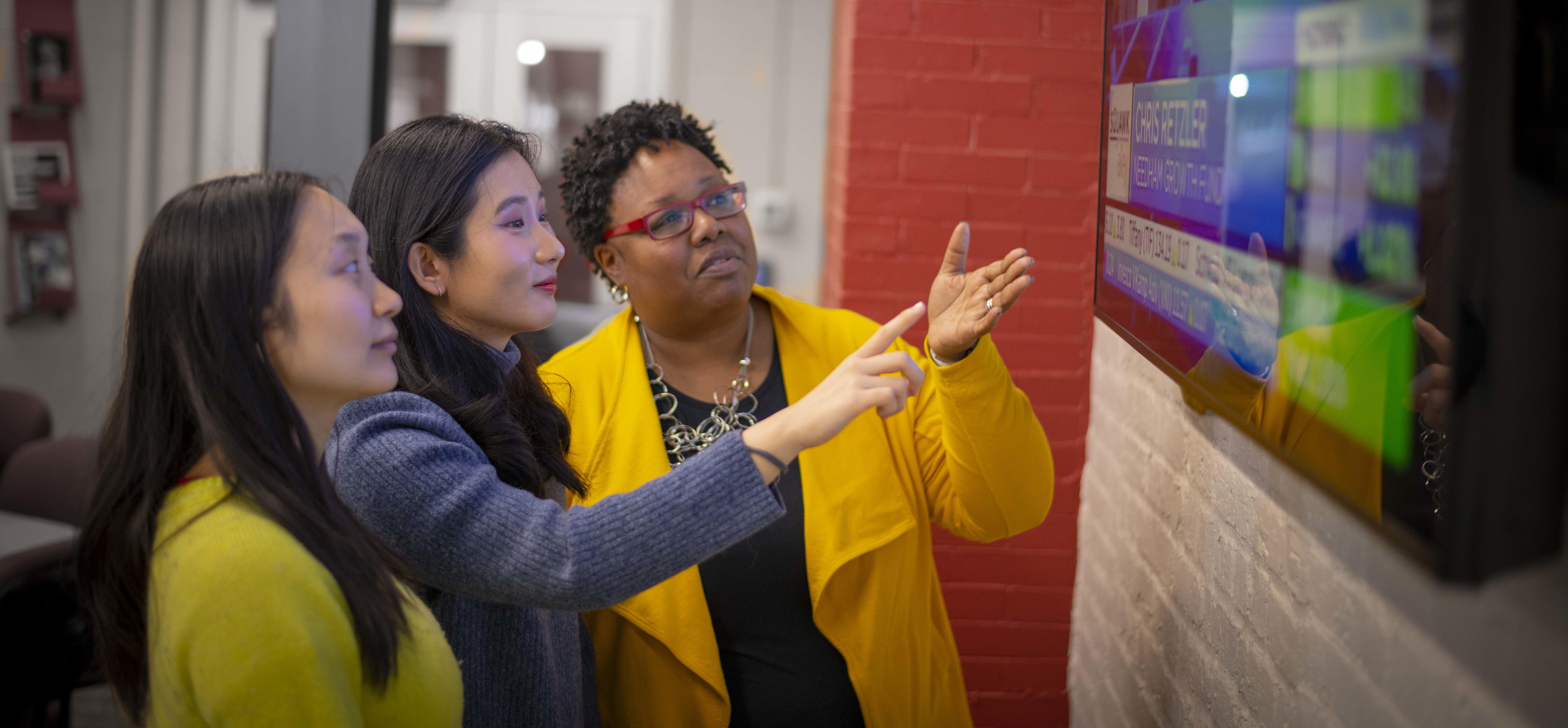 three women looking at a screen