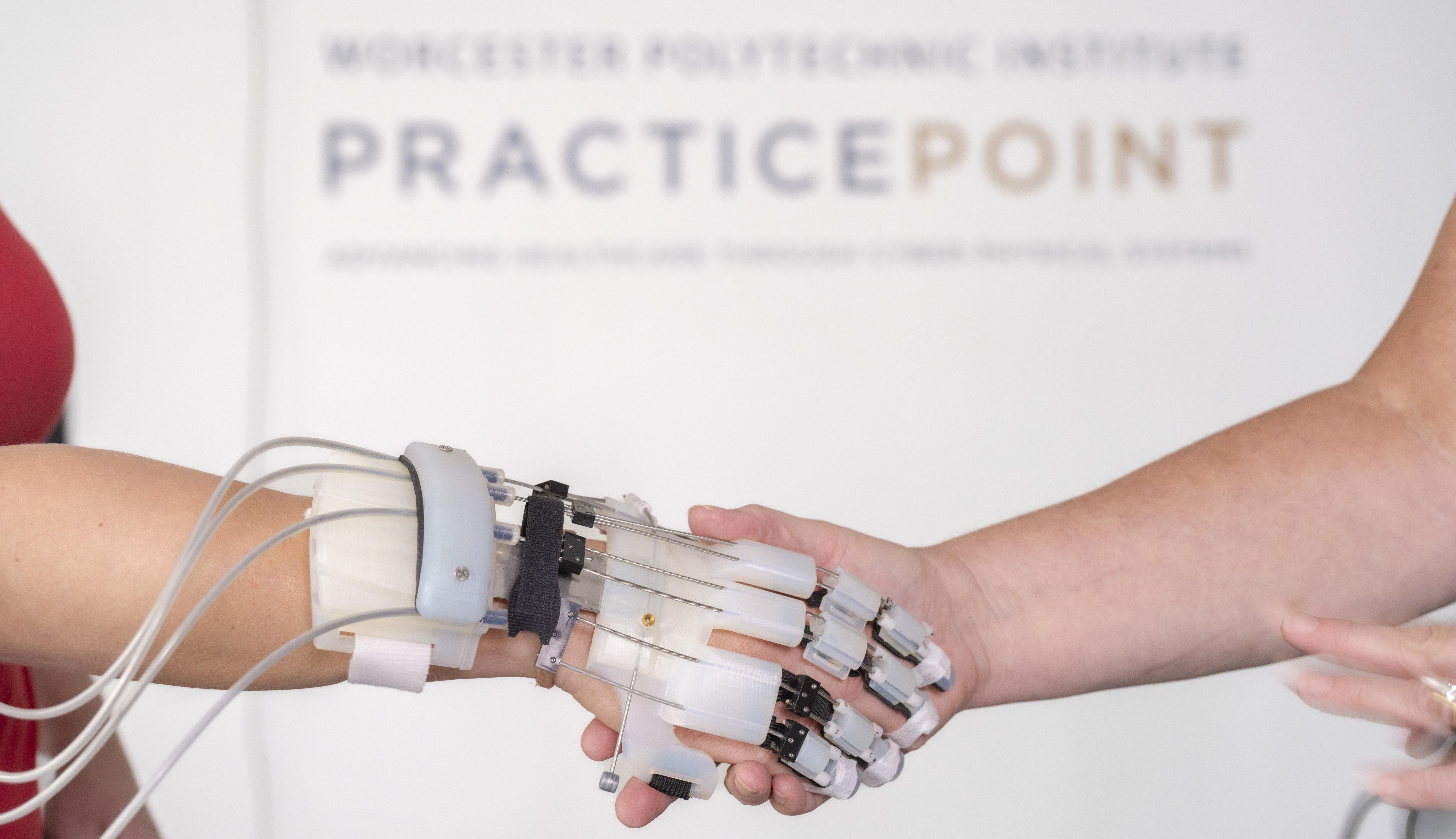 robotic device on hand shaking a human hand with PracticePoint logo in background