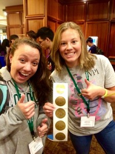 Julie Mazza’16 (left) and Kayla DeSanty ’16 show off the gold at iGEM in Boston.