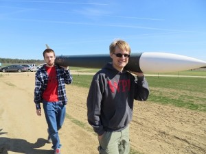 Kyle Foster and Jeffery Tolbert ’17 carry their rocket to the launch pad.