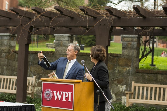 Eric Overström accepts a bottle of wine from President Laurie Leshin.
