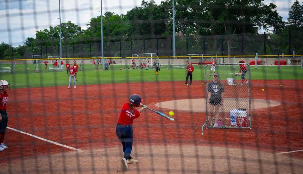 A photo from behind home plate of WPI students practicing softball