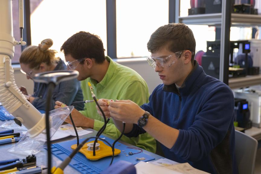 Students soldering components together in a mechanical engineering lab