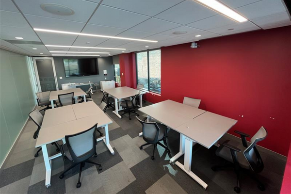 picture of boardroom setup in pods with tables, chairs and display monitor