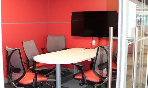 picture of technology suite with chairs, table and monitor