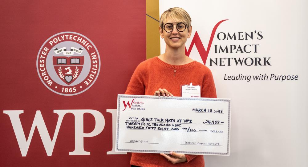 one woman poses with large check