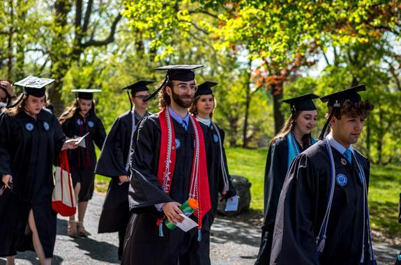 WPI graduate students walking outside during commencement on a sunny day
