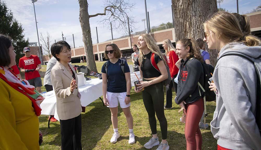 Grace Wang chats with students on Higgins House lawn.