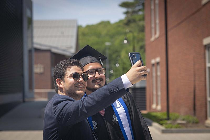 Students at Commencement taking a selfie.