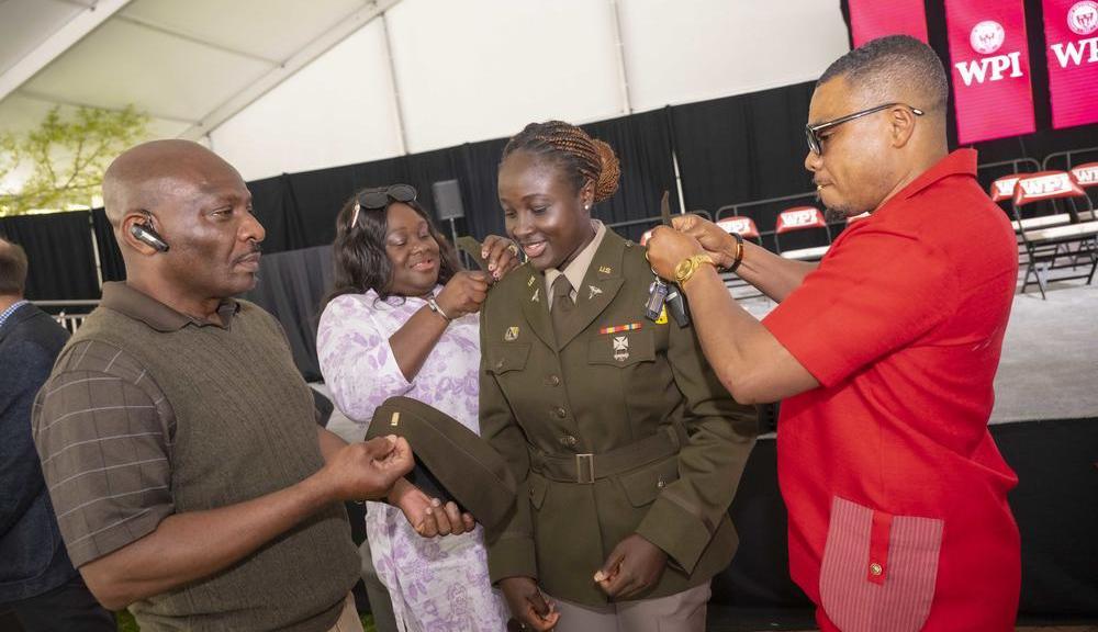 Family members participate in the ROTC commissioning ceremony for a graduating cadet.