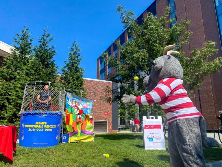 Gompei throwing a ball at a dunk tank