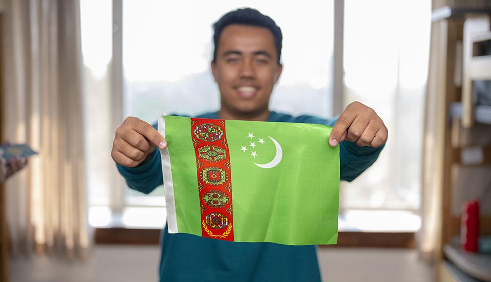 Jelaleddin Gylychmuhammedov, shows off the flag of Turkmenistan, 